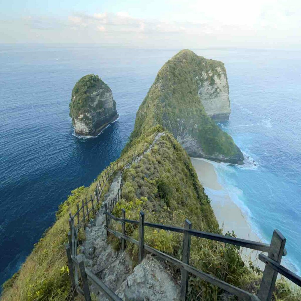 Travel destination Indonesia: diverse landscapes, featuring volcanoes, waterfalls, and stunning beaches like Kelinking Beach.