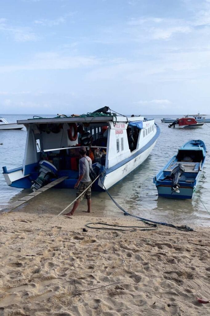 Bunaken Beach Harbor with boats docked along the shore and clear blue water.