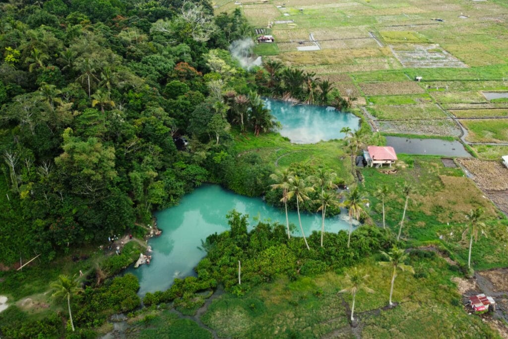 Aerial view of Ranolewo Hot Springs surrounded by tropical forest