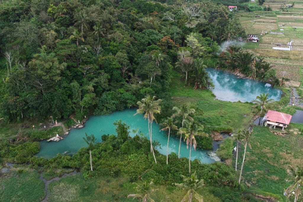Drone view of Ranolewo Hot Springs surrounded by tropical forest